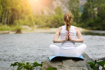 Fototapeta premium Woman in Lotus position near the river.