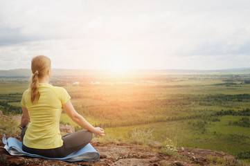 Fototapeta premium Woman in Lotus position on top of the mountain.