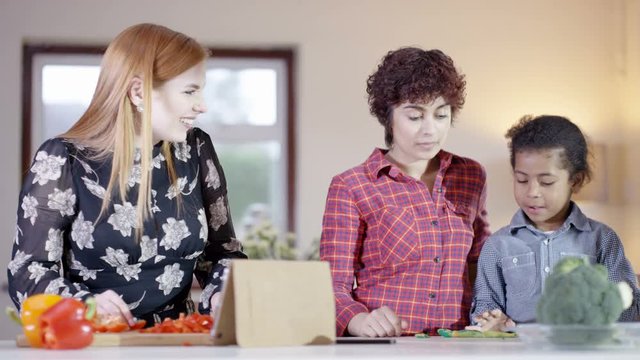  Gay Female Couple At Home Preparing A Meal In Kitchen With Young Son