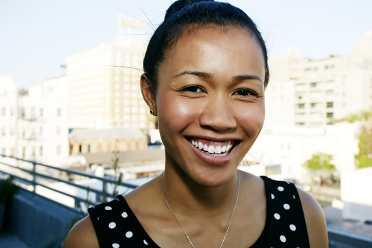 Mixed race woman smiling on urban rooftop
