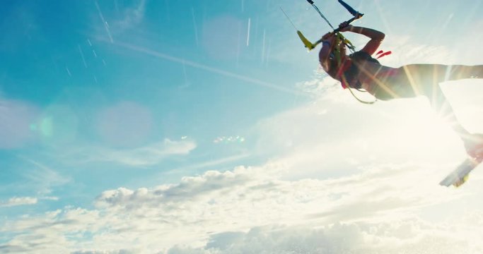 Beautiful young woman kiteboarding at sunset in slow motion, active lifestyle extreme sport