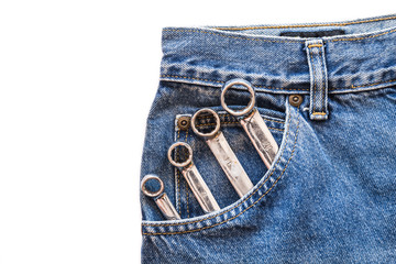 chrome lug  spanner in front blue jeans pocket on white isolated background. Copy space for text