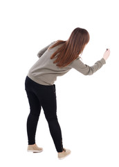 back view of writing beautiful woman. Rear view people collection.  backside view of person. Isolated over white background. A young girl in a gray jacket leaned marker drawing.