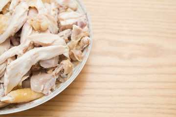 dish of shredded boiled chicken on wood table with copy space
