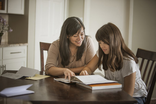 Mother helping daughter with homework