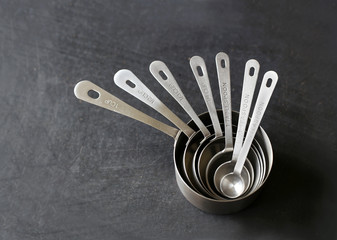 Silver Measuring Cups Stacked on Black Background