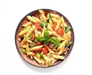 pasta with meat and basil on a plate on a white background