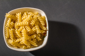 macaroni pasta in plate on black background