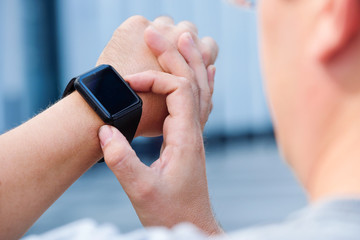 man checking his smartwatch outdoors. High angle shot.
