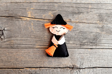 Halloween cute felt witch with broom on old wooden background. Halloween little witch ornament crafts for kids. Handicraft felt decor. Tutorial. Step. Top view