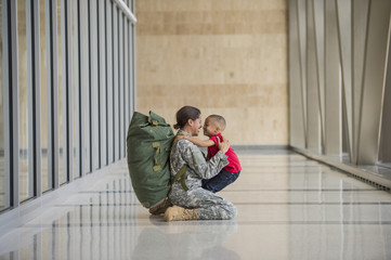 Female soldier hugging son in airport