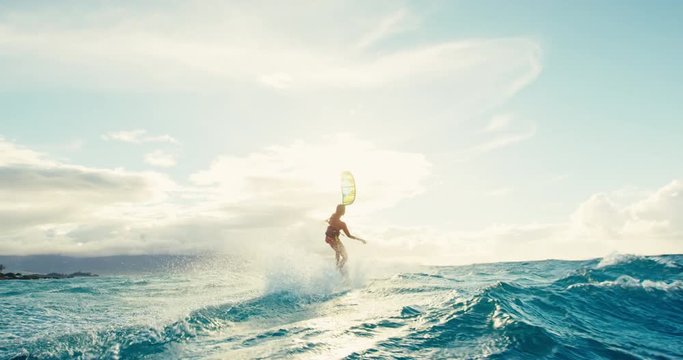 Beautiful young woman kiteboarding at sunset in slow motion, active lifestyle extreme sport