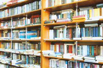 blurred bookshelf in library for your background design
