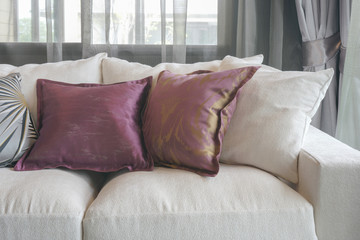 Fototapeta na wymiar Purple pillows on white sofa in living room