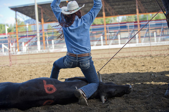 Cowgirl cheering after successfully tying cow
