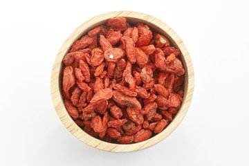 goji berry in wooden cup on white background.