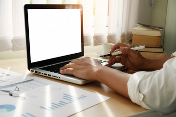 Fototapeta premium business man use on-line via laptop computer for analyzing financial chart,writing business plan,open net-book,phone,tablets,with copy space screen,morning light,vintage color
