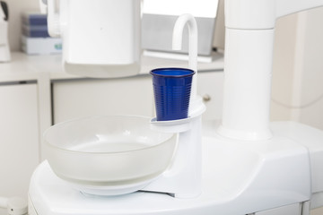 Fototapeta na wymiar Blue Glass On Dentist Chair At Clinic