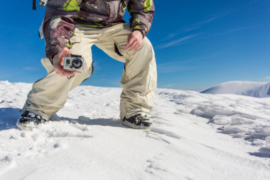 a man filming with action camera in snowy mountain range