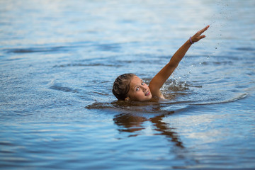 Little girl floating on the river. Bathing.
