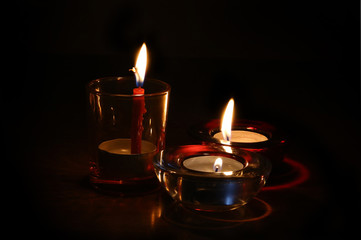Three burning candles in the dark