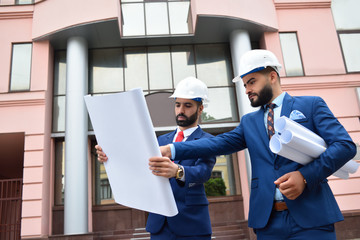 Two Arab architects looking at the plan outdoors