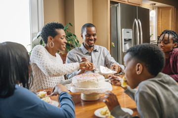 Black family eating cake at birthday party