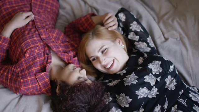  Gay female couple taking selfie in bedroom. Shot on RED Epic