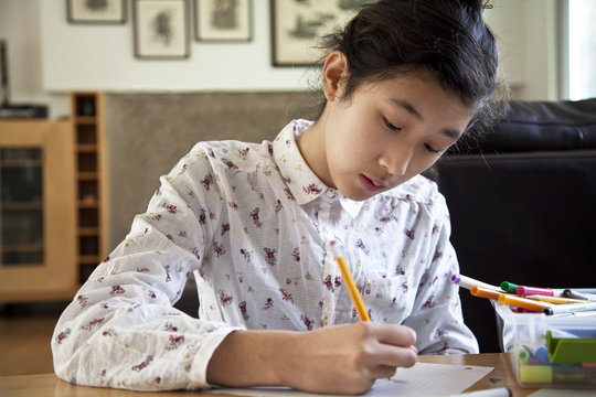 Close Up Of Asian Teenage Girl Doing Homework