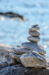 Fototapeta na wymiar Zen stones against blue sea bokeh