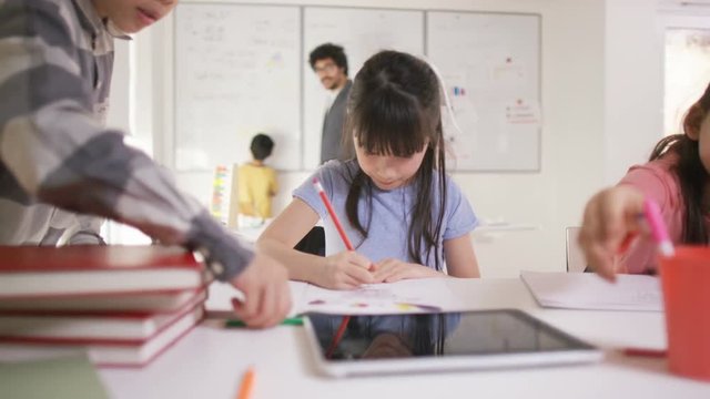  Portrait of happy little girl working at her desk in school classroom
