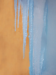 heat and cold, icicles on a background of warm wall