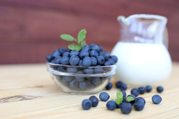 Blueberry on wooden background. Blueberry close up and blueberry background. Berries closeup. Blueberry with milk
