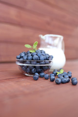 Blueberry on wooden background. Blueberry close up and blueberry background. Berries closeup. Blueberry with milk
