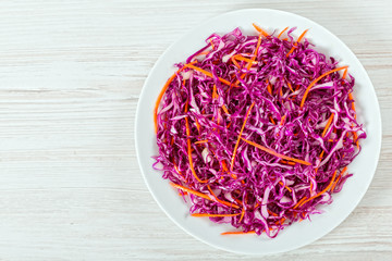 Salad coleslaw - red cabbage with carrots on white dish