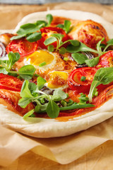 Fototapeta na wymiar Home Italian pizza with tomato and quail eggs salad