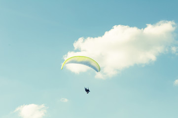 Paraglider flying up in the blue sky