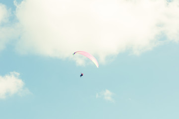 Paraglider flying up in the blue sky