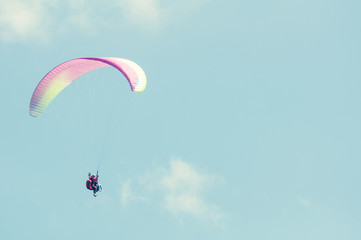 Tandem paragliding flight on sunny blue sky