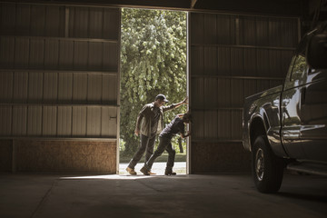 Father and son opening barn door