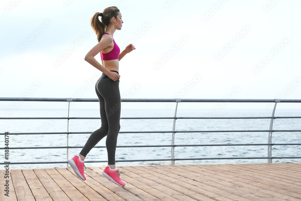 Poster young woman running on pier