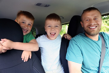 Handsome father with sons in car