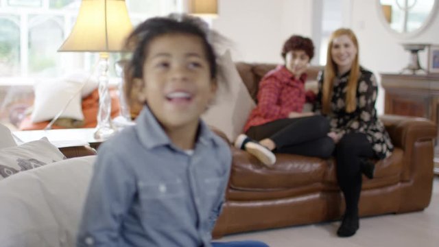  Portrait of gay female couple with young son with focus on little boy