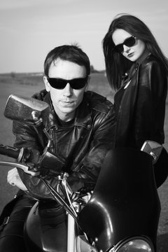 Biker man and girl stands on the road
