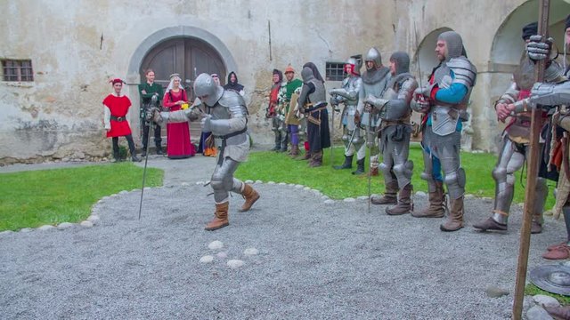 One of the last knights is coming out of the row and is introducing himself to the audience. Wide-angle shot.
