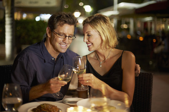 Caucasian couple toasting with wine in restaurant
