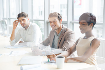 Business people sitting on training and making notes in office