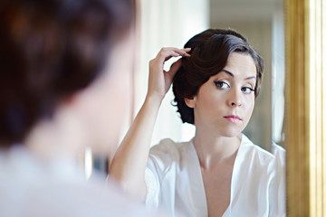 Beauty bride in dressing gown with bridal makeup indoors. Beautiful model girl in colorful wedding robe. Female portrait of cute lady. Woman with hairstyle