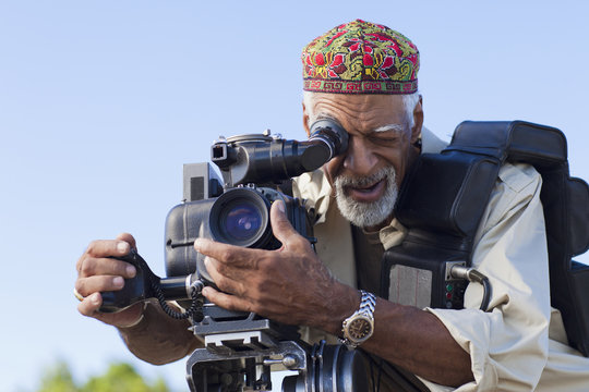African American man using film camera - Powered by Adobe
