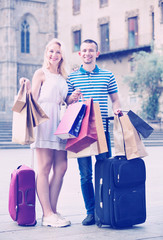Young man and woman holding shopping paper bags